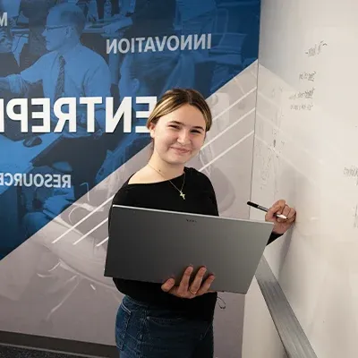 A girl stands at a whiteboard